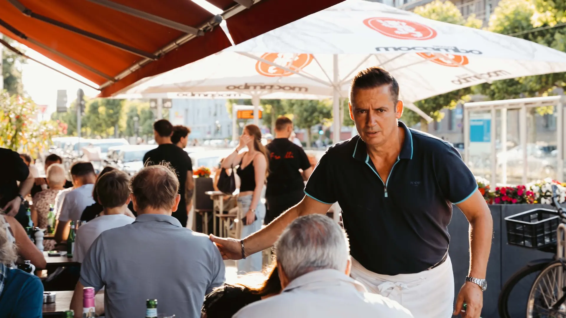 Gastgeber begrüßt Gäste auf der Terrasse der Pizzeria Fratelli in Düsseldorf-Oberkassel